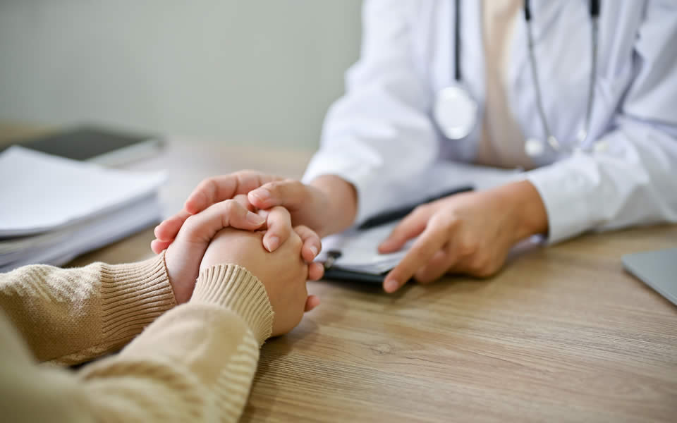 Close up view of doctor touching patient hand, showing empty and kindness - Australian Menopause Center